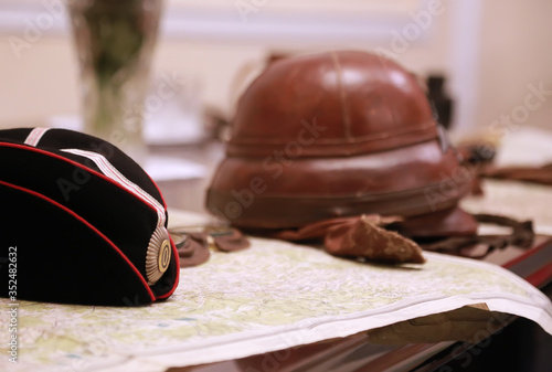 Military Black Garrison Cap and helmet of russian pilot on the map. I World war uniform. Vintage concept.