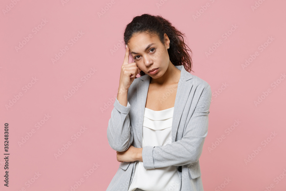 Concerned young african american business woman in grey suit white shirt posing isolated on pink background in studio. Achievement career wealth business concept. Mock up copy space. Put hand on head. Concerned young african american business woman in grey suit white shirt posing isolated on pink background in studio. Achievement career wealth business concept. Mock up copy space. Put hand on head.