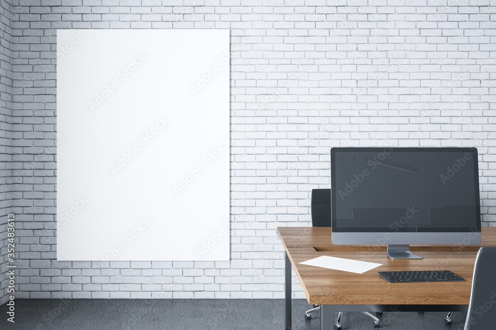 Workplace with computer on table and blank poster on brick wall. Workplace with computer on table and blank poster on brick wall.