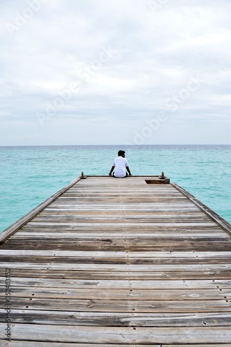 Man on Pier seeing the blue sea at Maldives