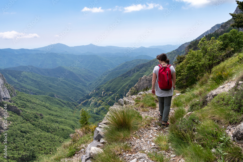 Female hiker on mountain pathway, Ligurian Alps, Italy