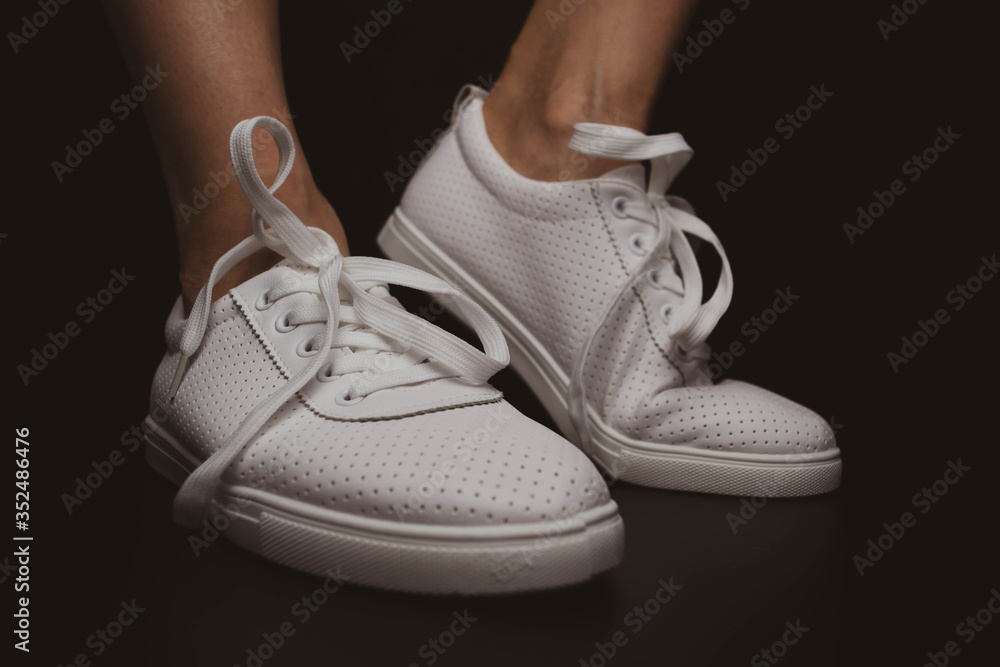 White sneakers on a black background. White sneakers on a black background.