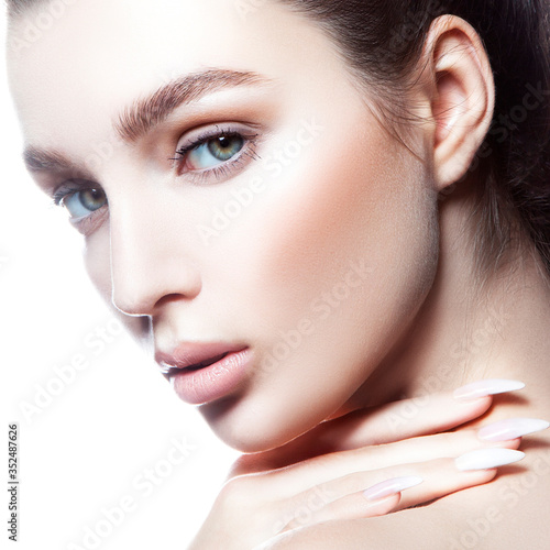 Beauty face. Close- up portrait of sensual beautiful young model woman with perfect skin. Hand near neck  natural nude make-up. Isolated. White background