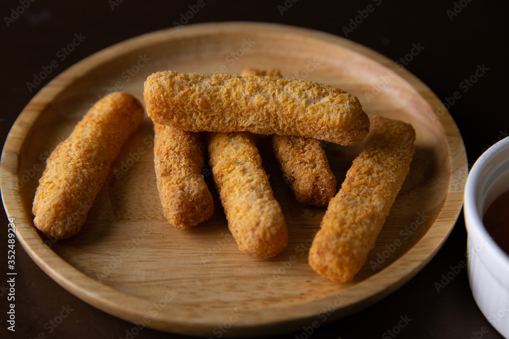 Nuggets on a wooden plate on a black background