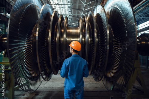 Worker checks turbine impeller vanes on factory photo