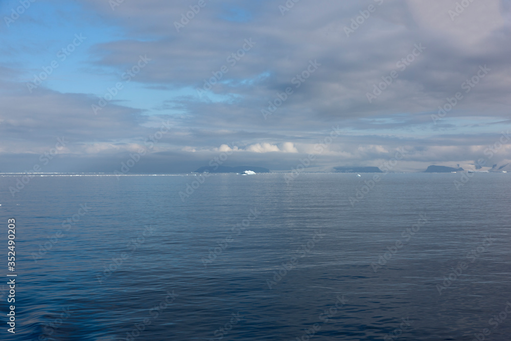 Antarctica landscape with sea and icebergs on a cloudy winter day