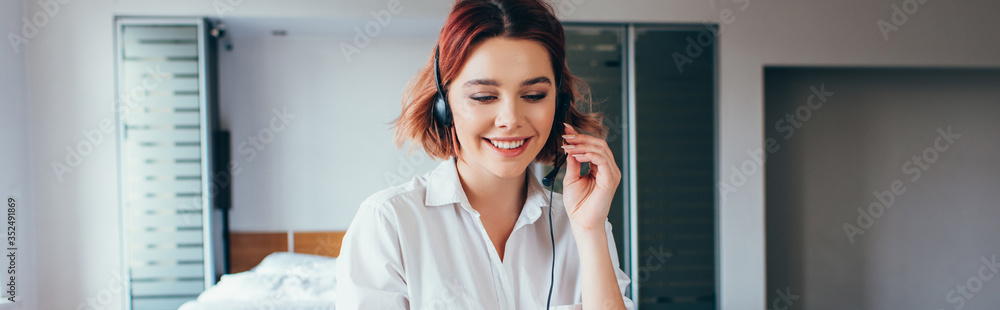 smiling female freelancer using headset to work from home on self isolation, horizontal crop smiling female freelancer using headset to work from home on self isolation, horizontal crop