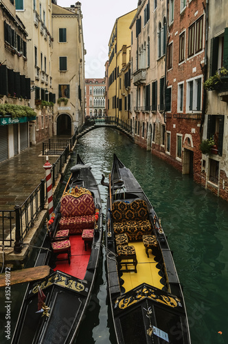 Venetian canal with gondolas and old facades of houses.