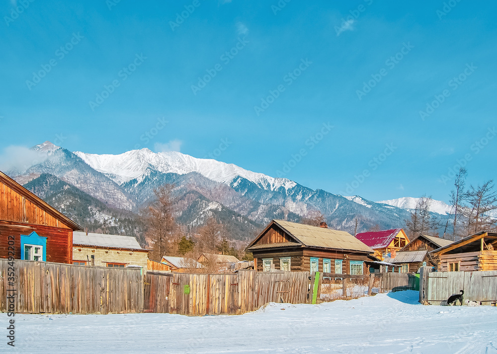 Village at the foot of the mountains in winter, winter background