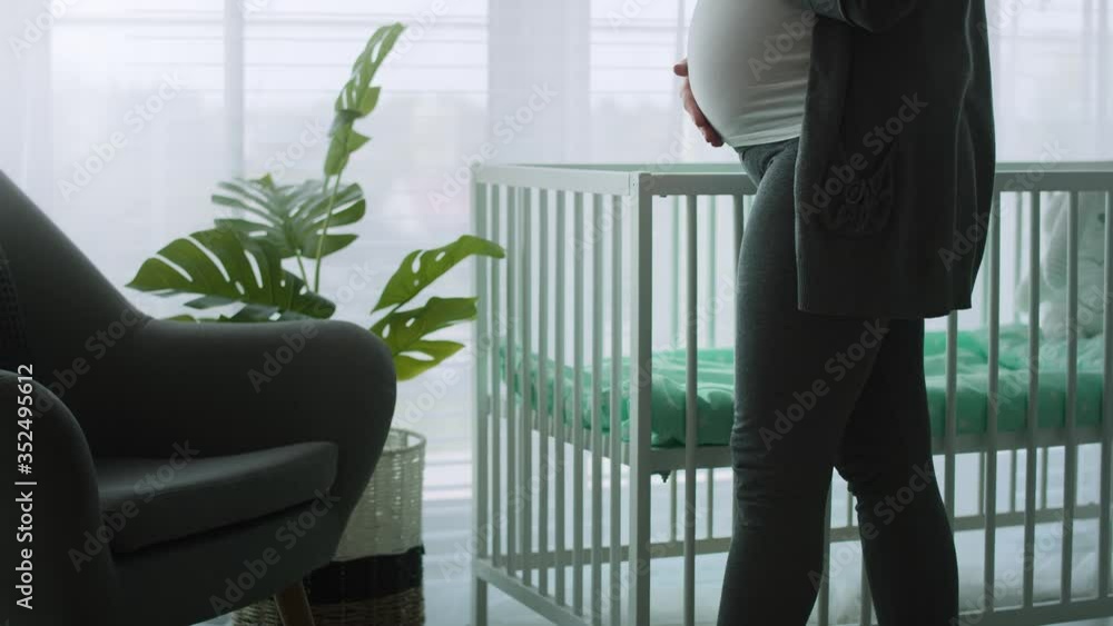 Tilt up video of pregnant woman strobing her advanced abdomen. Shot