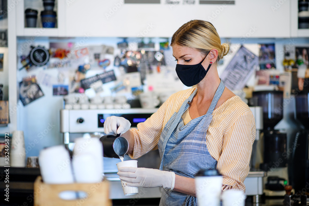 Coffee shop woman owner working with face mask, open after lockdown quarantine. Coffee shop woman owner working with face mask, open after lockdown quarantine.