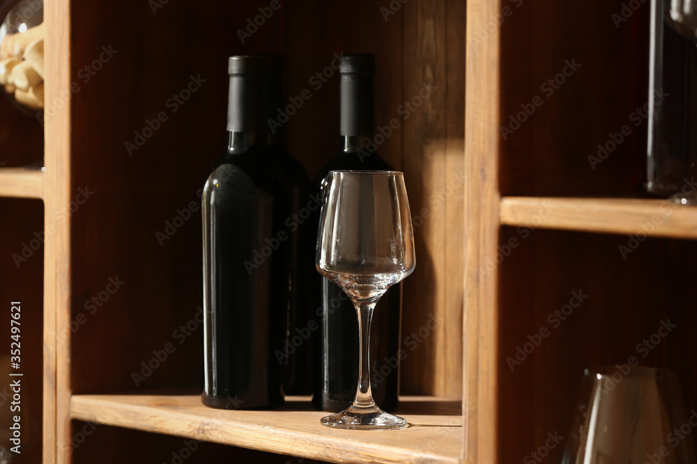Bottles of wine and glass in cellar