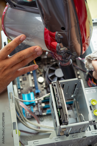 Cleaning and fixing the personal computer (PC) with a vacuum cleaner. Computer service and maintainance.