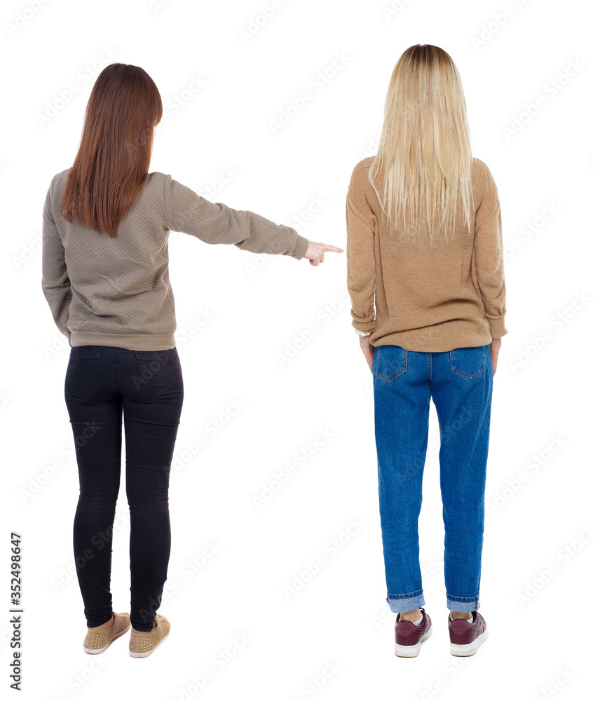 Back view of two young woman photographed on a mobile phone in sweater. Back view of two young woman photographed on a mobile phone in sweater.