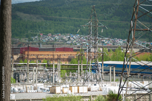 industrial city, power plant, green mountains in the background