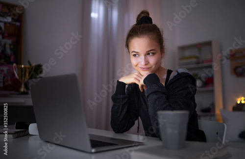 Beautiful happy young girl with laptop sitting and smiling, online dating concept.