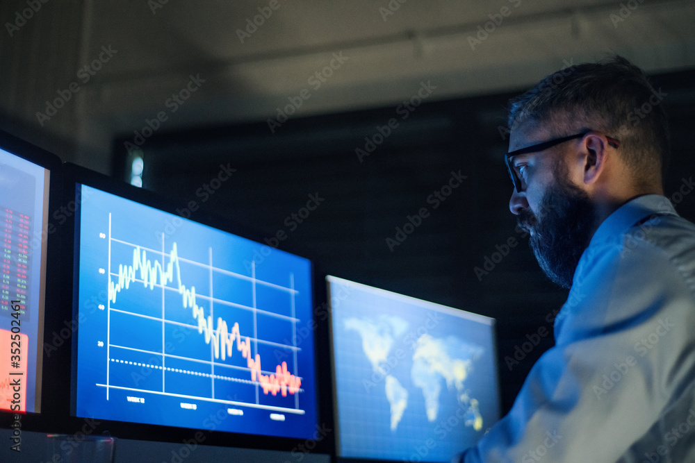 Businessman with computer sitting at desk, working late. Financial crisis concept. Businessman with computer sitting at desk, working late. Financial crisis concept.