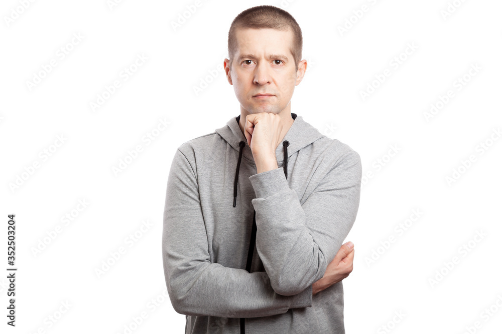 thoughtful, calm man athlete makes a decision, hands are crank, at the chin. Dressed in a grey hooded jacket. Look in upwards. Isolated thoughtful, calm man athlete makes a decision, hands are crank, at the chin. Dressed in a grey hooded jacket. Look in upwards. Isolated