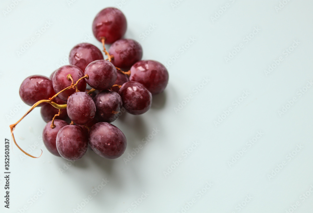 bunch of ripe grapes on a light background