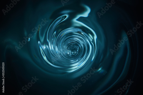 Smooth and beautiuful blue vortex. Whirlpool, water swirl, top view. High speed liquid photography. photo