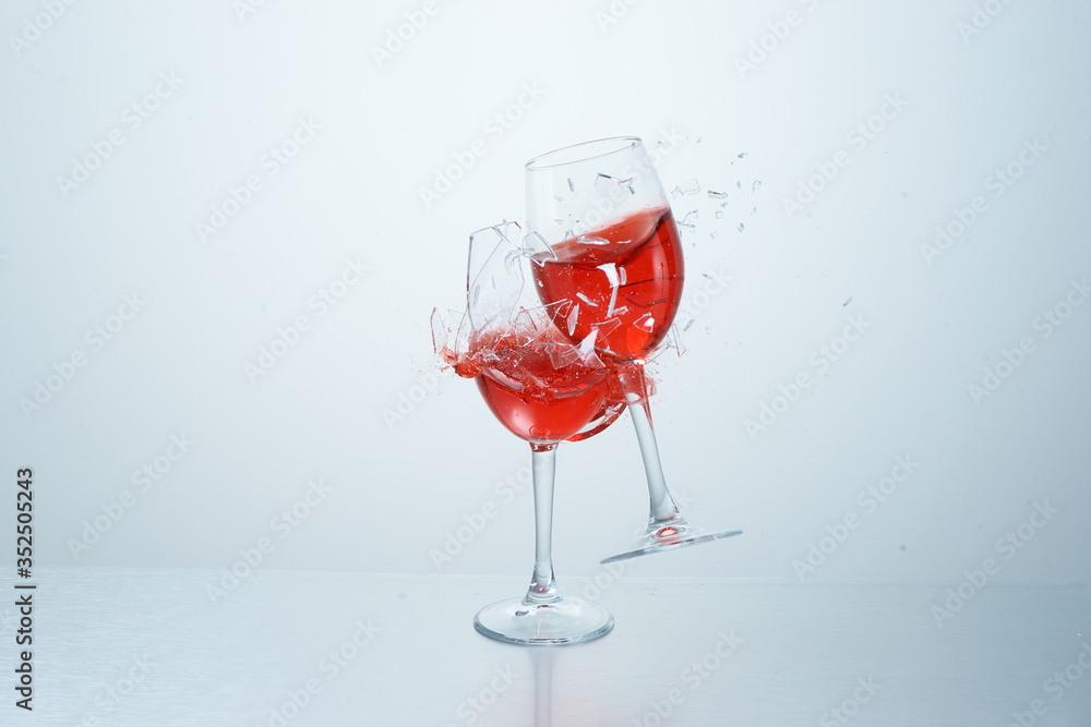 Red wine glasses flying, colliding and crushing on white background. Splashes. Broken glass. High speed photography of liquids Red wine glasses flying, colliding and crushing on white background. Splashes. Broken glass. High speed photography of liquids