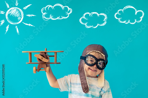 Happy child playing with toy wooden airplane