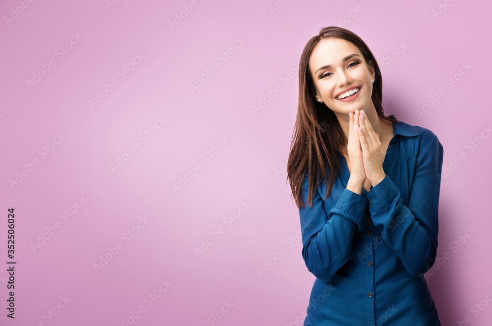 Portrait of happy gesturing dark haired woman in casual smart blue clothing, pressing palms together, over purple background, with copyspace for slogan, advertising or text message Portrait of happy gesturing dark haired woman in casual smart blue clothing, pressing palms together, over purple background, with copyspace for slogan, advertising or text message