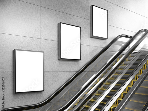Side view of escalator on wall background with three blank light box. 