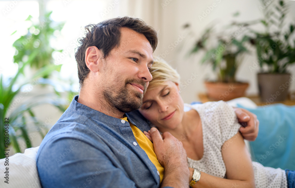 Happy couple in love sitting indoors at home, hugging. Happy couple in love sitting indoors at home, hugging.