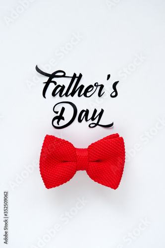 Fathers Day greeting card. Cute poster with red bow tie for best Dad on  white background. Paper cut lettering.
