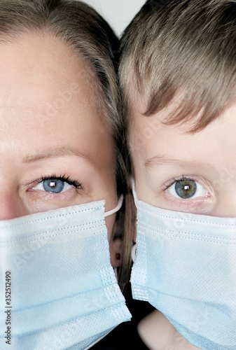 Studio portrait of young blond woman and 6 years boy in face mask for protect during quarantine covid-19 pandemic. Caucasian mother and son. Coronavirus concept. photo