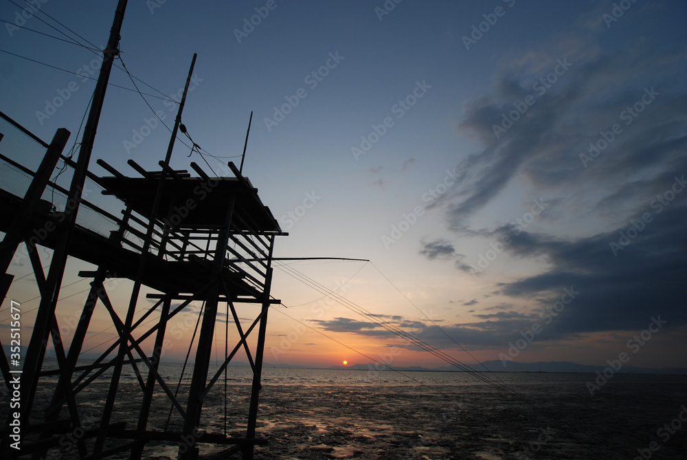 有明海に沈む夕日と古式漁法くもで網漁