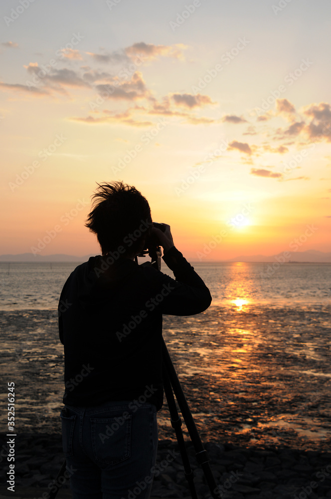 有明海に沈む夕日を撮影するカメラマン