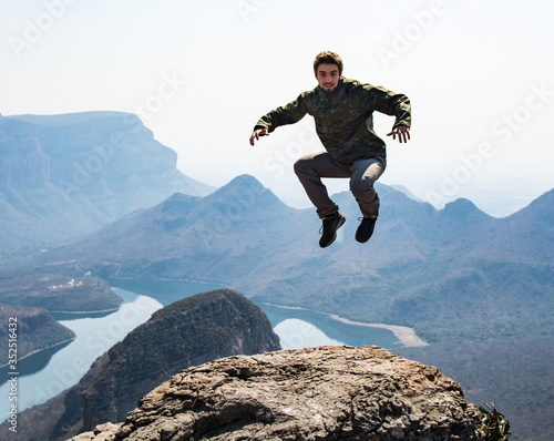 Risky young man jumping on the top of Blyde River Canyon, South Africa.