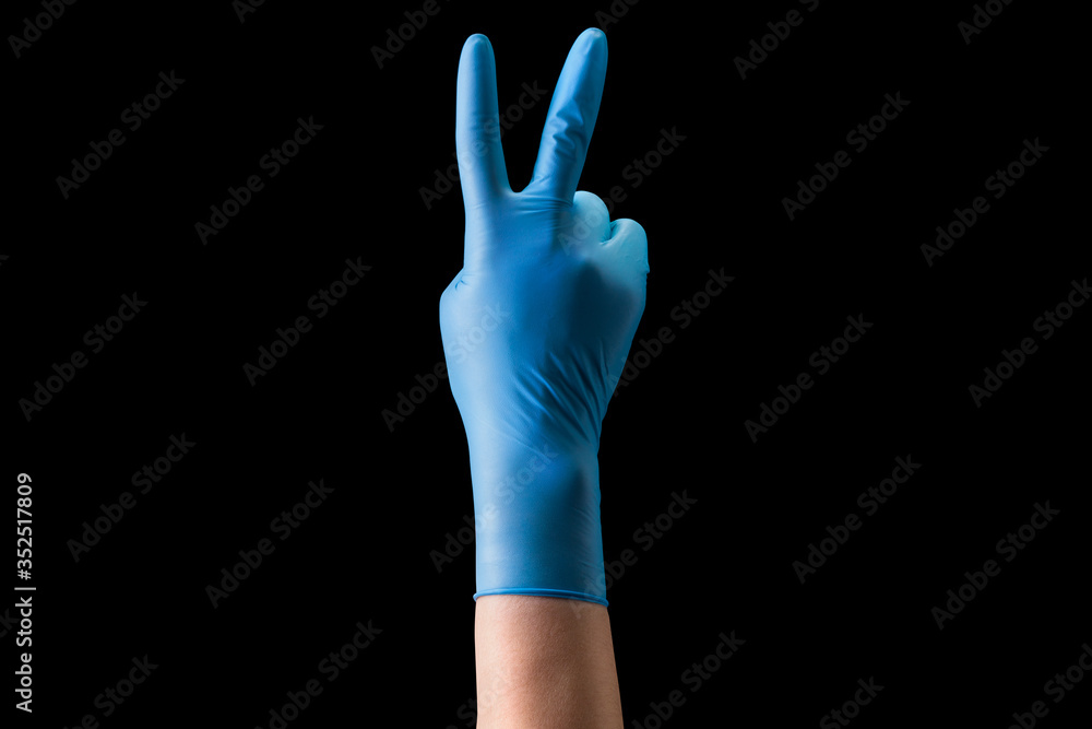 Doctor's hand in medical gloves showing two fingers up in peace symbol isolated Doctor's hand in medical gloves showing two fingers up in peace symbol isolated