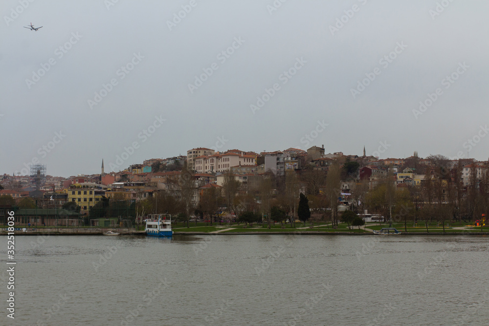 Naklejka premium View of a residential area of Istanbul from the Golden Horn Bay in rainy weather. Turkey