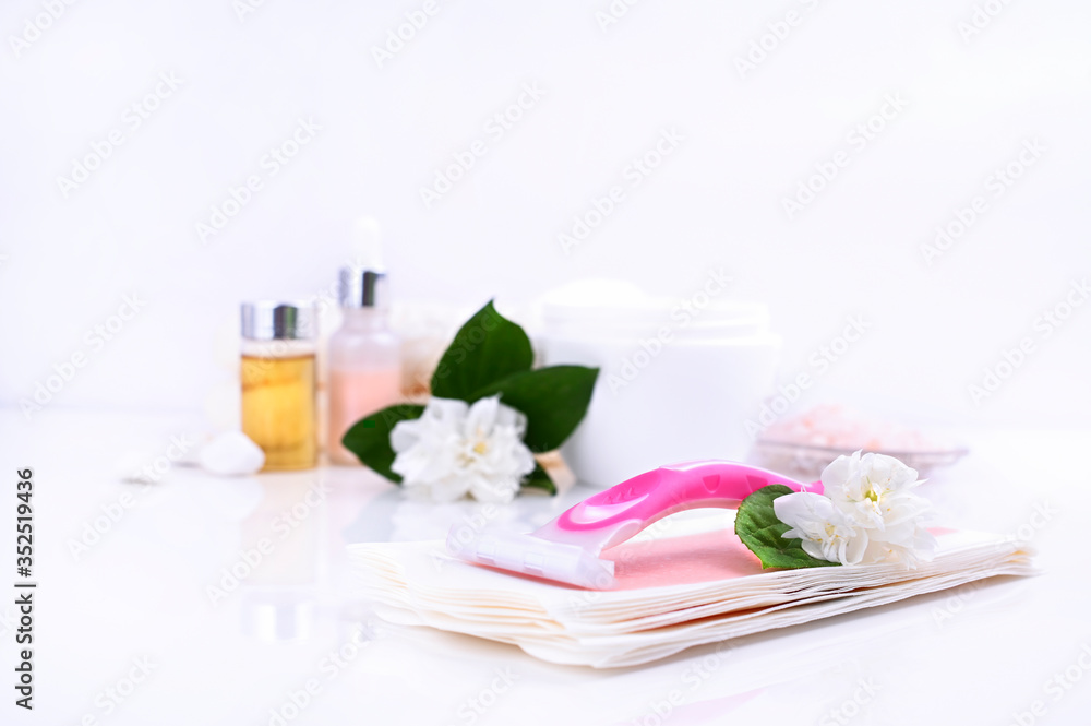 a set of different means for epilation on a colored background. Removal of unwanted hair. Body care products, creams, emulsion, towel, jasmine flowers, wax strips, razor. Minimalism, top view. flatlay