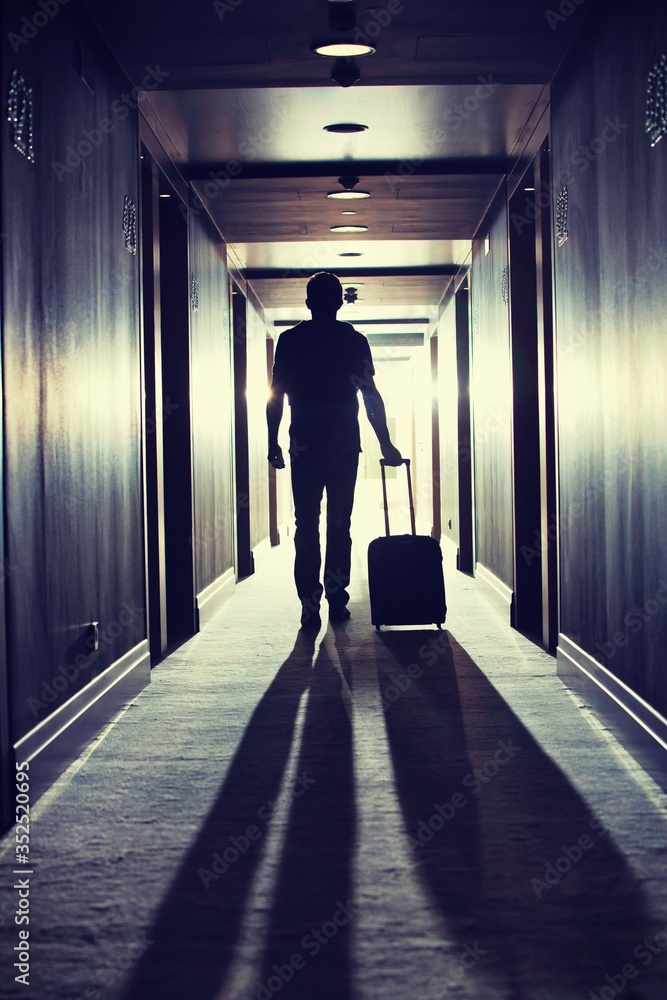 Rear view of man walking with his suit case in hotel
Rear view of man walking with his suit case in hotel