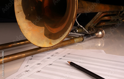 Pencil, sheet music and trombone