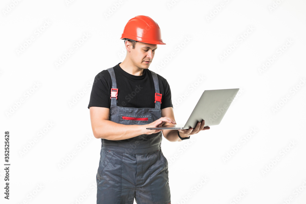 Full body view of a construction contractor working on his laptop on white background Full body view of a construction contractor working on his laptop on white background