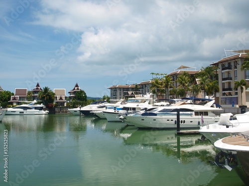 Panoramic view of the promenade of a coastal town. City block for rich. Residential homes and moored yachts nearby. Luxury and wealth. Villas and apartments. Yacht club, hotel. Cloudy, calm, nobody