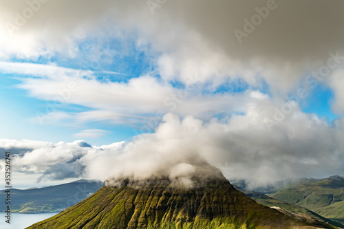 Foggy mountain peaks and clouds covering sea and mountains. Panoramical view from famous place - Sornfelli on Streymoy island, Faroe islands, Denmark. Landscape photography photo