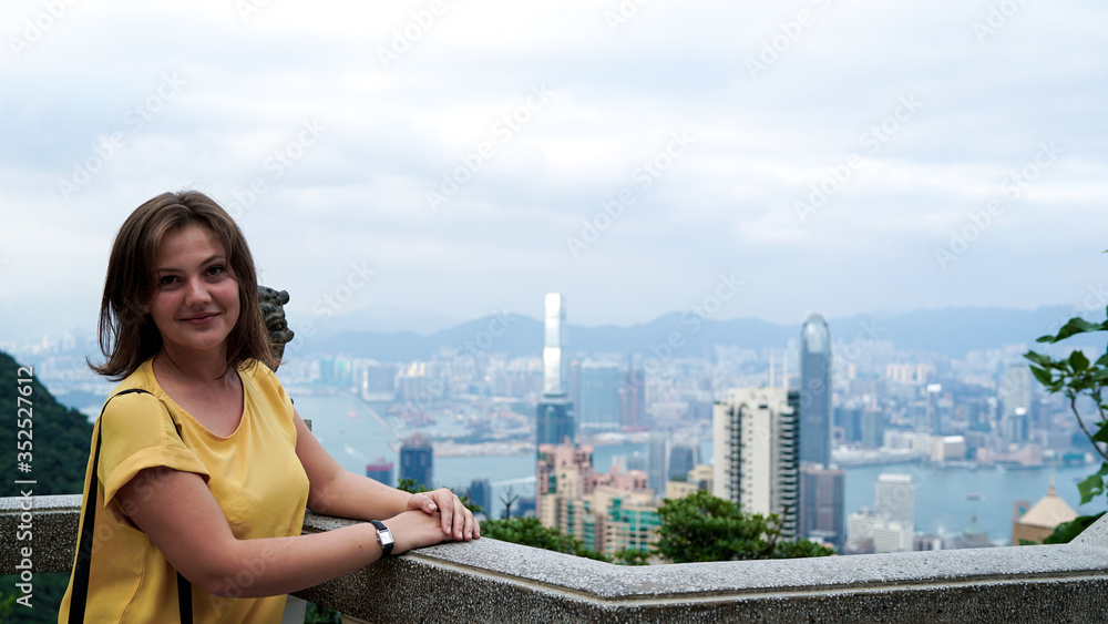 young beautiful happy tourist woman looking at the city, Hong Kong viewpoint, copy-paste text, travel concept