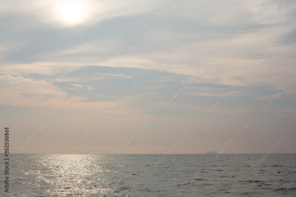 Natural background. The sun goes down to the horizon above the sea or ocean. Sunset over the water.