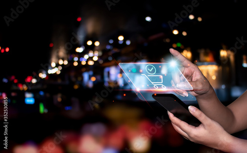 General people who use mobile phones In online trading and payment for online purchases and online banking transactions, Colorful bokeh lights in the city Background.