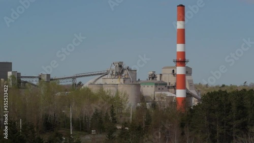 Industrial cement plant buildings and smoke stack    photo
