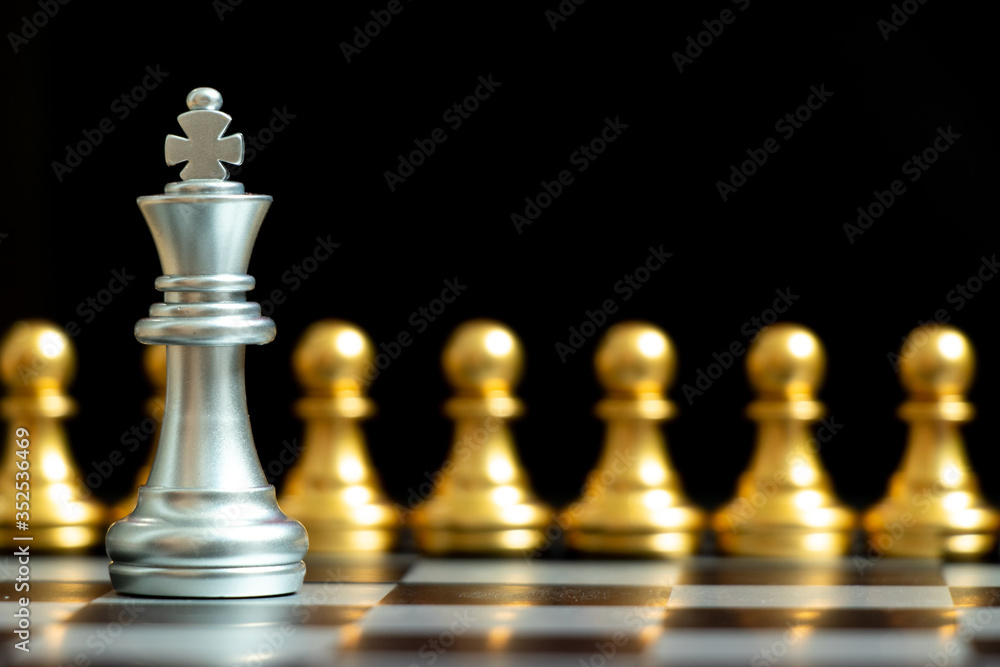 Silver king chess piece face with gold team on black background (Concept for company strategy, business decision and encounter the problem) Silver king chess piece face with gold team on black background (Concept for company strategy, business decision and encounter the problem)