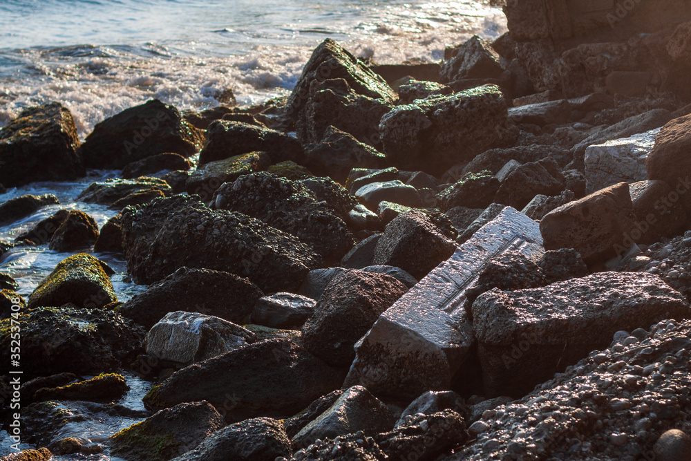 Splashes and waves in the evening light, fragments of ancient ruins Splashes and waves in the evening light, fragments of ancient ruins