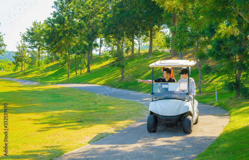 Professional golfers are driving golf cars to explore the golf course. Beautiful golf course.