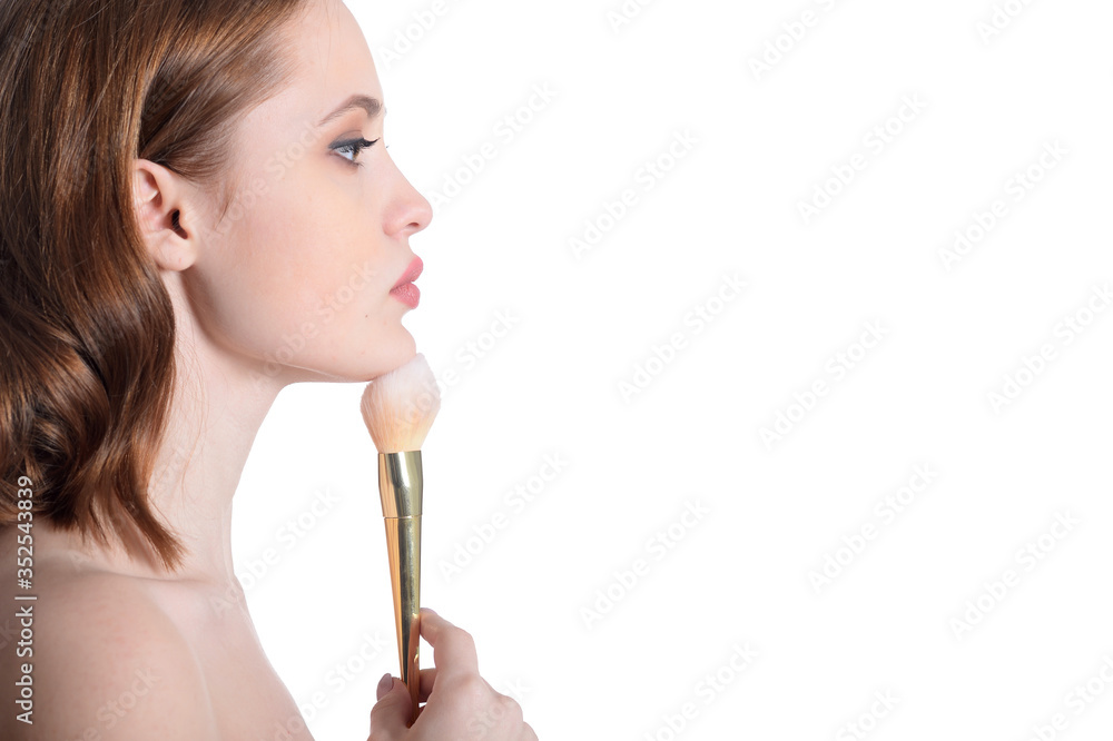 Portrait of beautiful young woman posing with make up brush